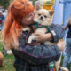 A lady with red hair cuddling her dog at the Wagfest dog show